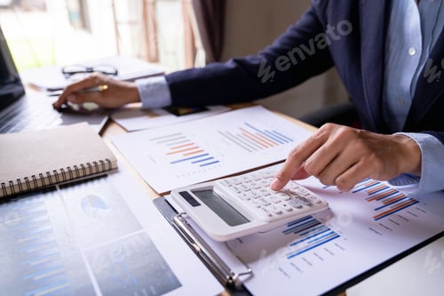 Preview: Close up woman hand using a calculator and writing make note, Tax Calculator And Pen, doing his acco