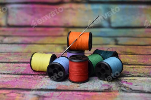 Preview: some spools of yarn and a needle through it