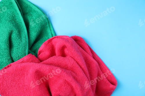 Preview: Bright terry towels on light blue background, above view. Space for text