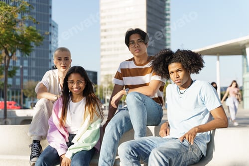 Preview: Cheerful interracial teen friends posing at camera outdoors