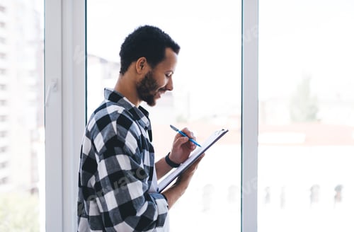 Preview: Successful Hispanic man with paperwork smiling
