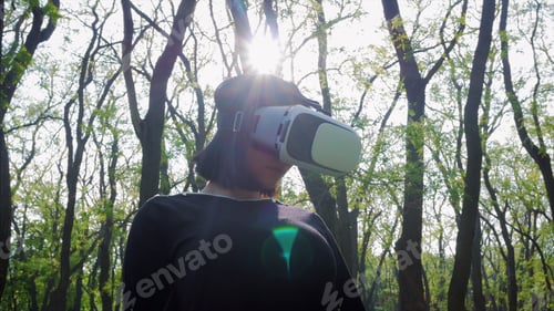 Preview: Young woman using virtual reality glasses in the park
