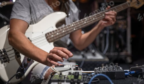 Preview: Guitar player on a stage with set of distortion effect pedals.
