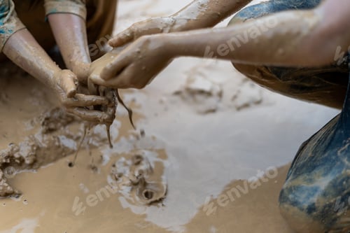 Preview: Hands of children playing in the mud