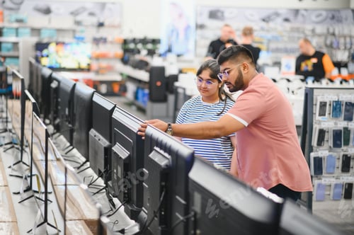 Preview: Beautiful couple buying consumer tech products in modern home appliances store