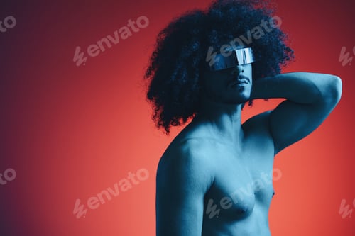Preview: Portrait of fashion man with curly hair on red background with stylish glasses, multinational