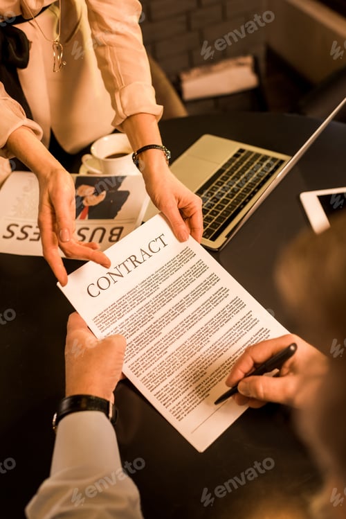 Preview: businessman signing contract during meeting with business colleague in cafe