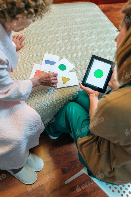 Preview: Female doctor showing geometric shapes to elderly patient