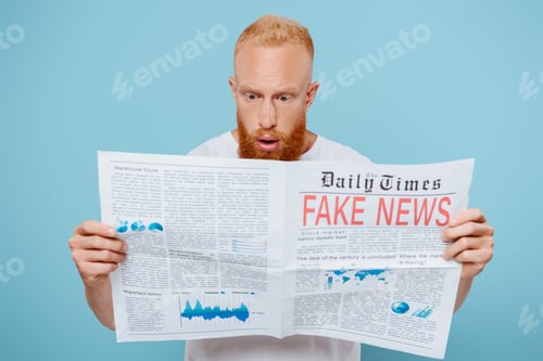 Preview: shocked bearded man reading newspaper with fake news, isolated on blue