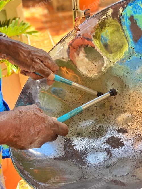 Preview: Diverse black senior man plays melodic and happy steel pan drums at a colorful outdoor festival