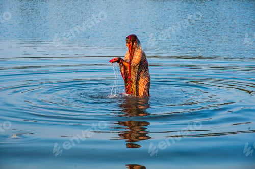 Preview: Traditionally dressed Indian woman pray into the river on Chhat Puja Festival.