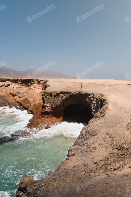 Preview: woman exploring the cliffs of the wild and desert coast of Fuerteventura