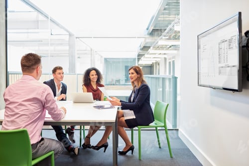 Preview: Businessmen and businesswomen meeting at office boardroom table