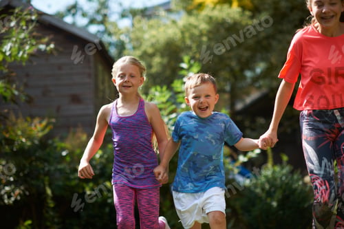 Preview: Siblings holding hands running in garden