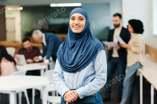 Preview: Portrait of beautiful smiling Arab woman wearing hijab, looking at camera