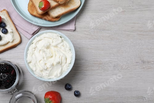 Preview: Tasty cream cheese, toasted bread and fresh berries on white wooden table, flat lay. Space for text