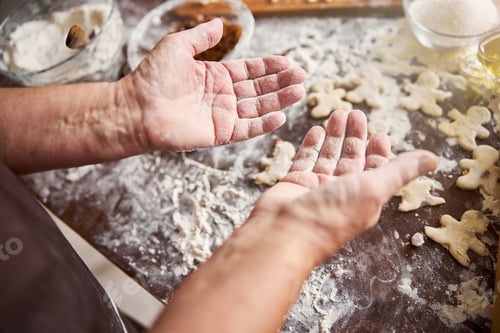 Preview: Hands of experienced baker being covered in flour