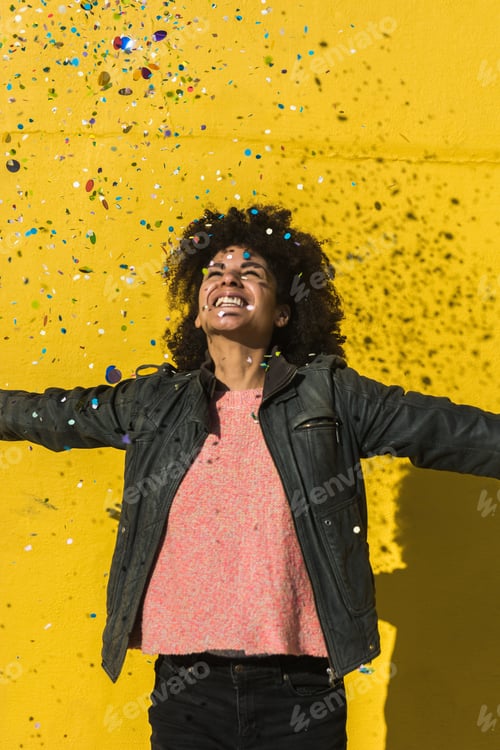 Preview: Black woman with afro hair celebrating with confetti.