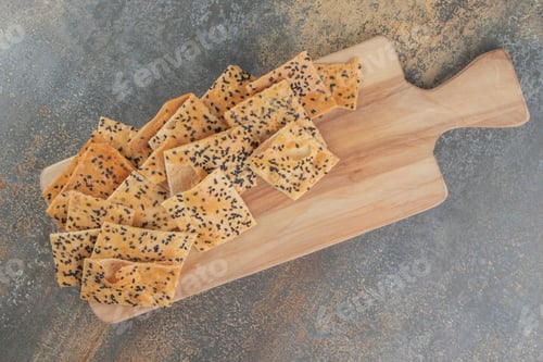 Preview: Tandoori bread slices with sesame seeds on board on wooden background