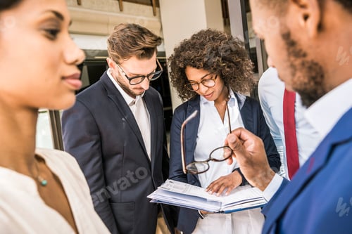 Preview: Business team preparing paperwork outside office