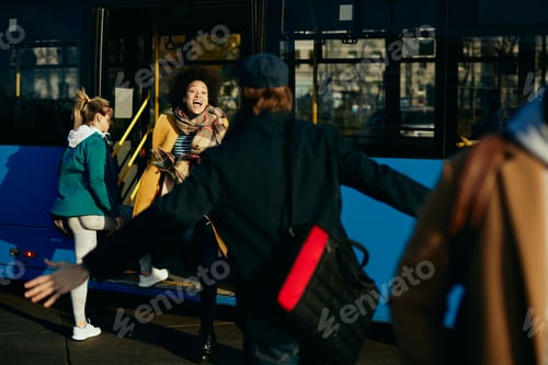 Preview: Happy Couple Meeting At Bus Station. Focus Is On African American Woman Running Into Man'S Embrace.