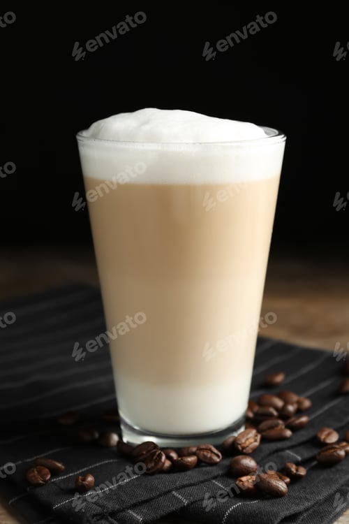Preview: Delicious latte macchiato and coffee beans on napkin