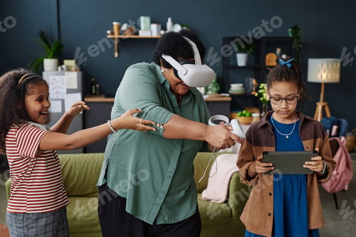 Preview: Black Grandmother Playing VR Game with Two Girls