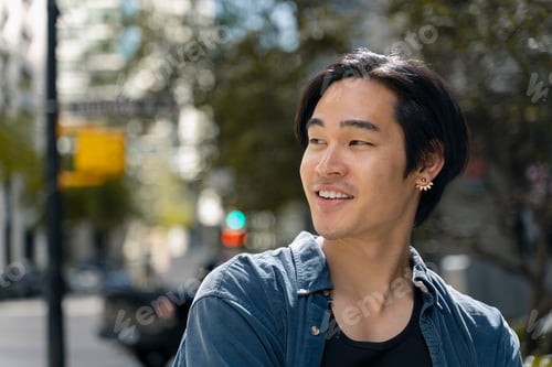 Vista previa: Portrait of attractive smiling asian man looking away standing on the street, copy space