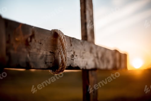 Preview: Selective focus shot of a hand made a wooden cross with rope wrapped around and blurred background