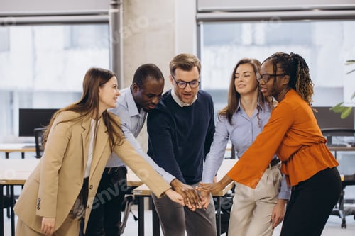 Preview: Diverse businesspeople joining hands in office, symbolizing teamwork, collaboration