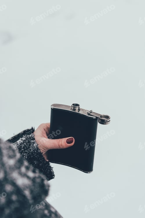 Preview: cropped shot of woman holding flask in hand on winter day