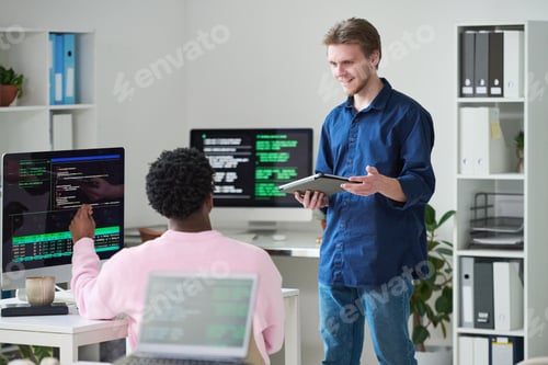 Preview: Young Man Discussing Project with Black Colleague in Office