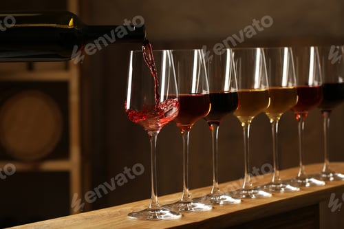 Preview: Pouring wine from bottle into glass in cellar
