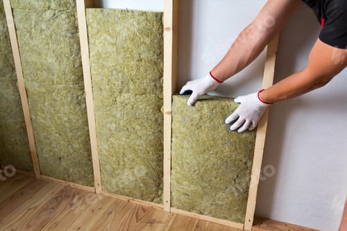 Preview: Close-up of worker hands in white gloves insulating rock wool insulation staff