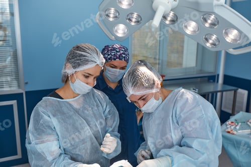 Preview: Concentrated Surgical team operating a patient in an operation theater