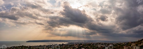 Preview: Dramatic clouds and sun rays in the sky over the city