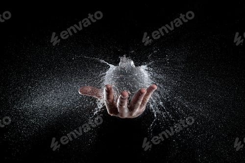 Preview: High-speed shot of the explosion of a water balloon held up by a person's hand on a black background