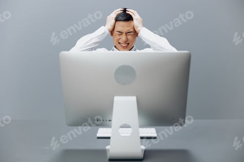 Preview: Asian man sits at a desk in front of a computer Internet technologies