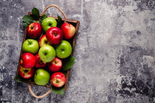 Preview: Ripe red and green apples in wooden box.
