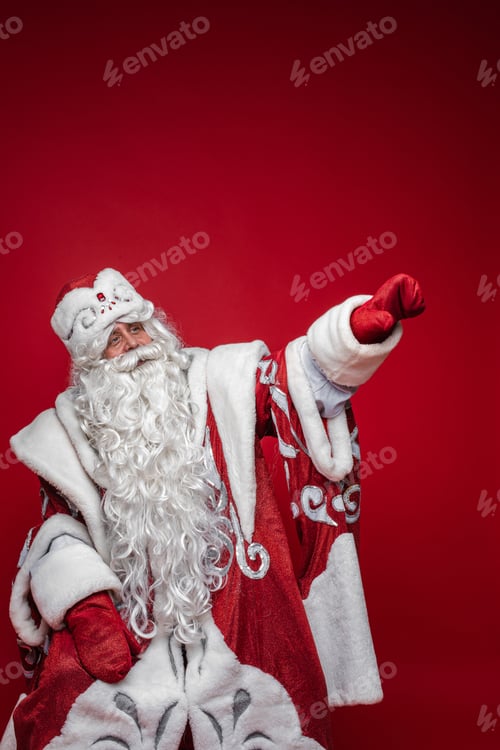 Preview: Santa Claus in facny costume pointing away with arm.