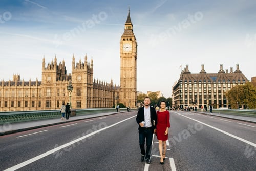 Preview: Female wears red elegant dress and man hold hands, have walk on Westminster bridge