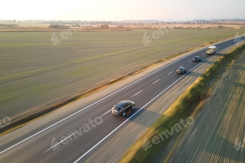 Preview: Aerial view of intercity road with fast driving cars at sunset.