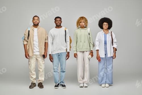 Preview: good looking stylish friends with backpacks standing still and looking at camera, student lifestyle