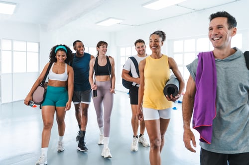 Preview: Group of smiling athletes walking through gym after functional training workout