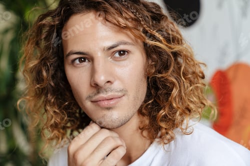 Preview: Handsome curly man indoors at home looking aside