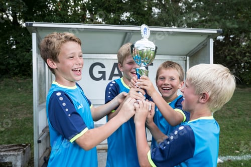 Preview: Young football players cheering with cup
