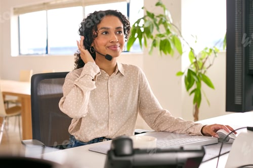 Preview: Woman Wearing Headset Working In Office Call Centre Sitting At Desk