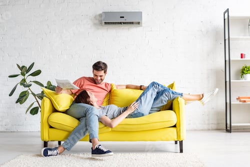 Preview: Couple Relaxing Together on Yellow Couch at Home