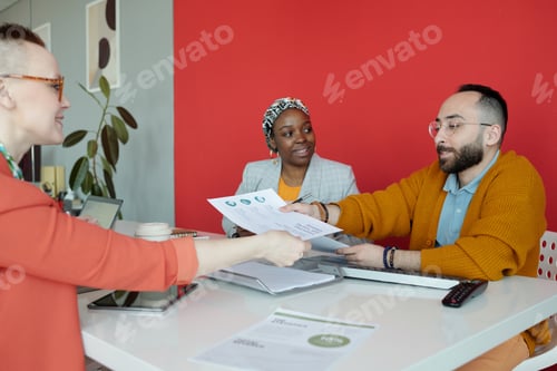 Preview: Colleagues Sharing Documents During Office Discussion