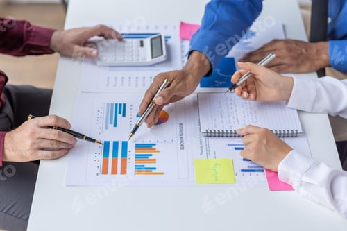 Preview: Group of confident business people point to graphs and charts to analyze market data, balance sheet,